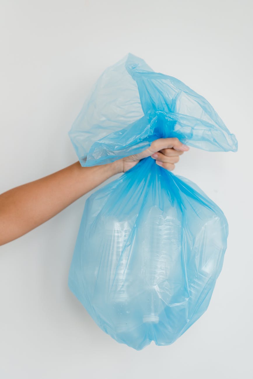 close up shot of a person holding a blue plastic bag