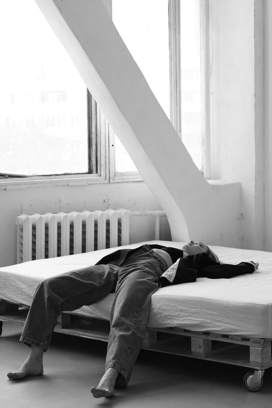 woman lying on bed in light room