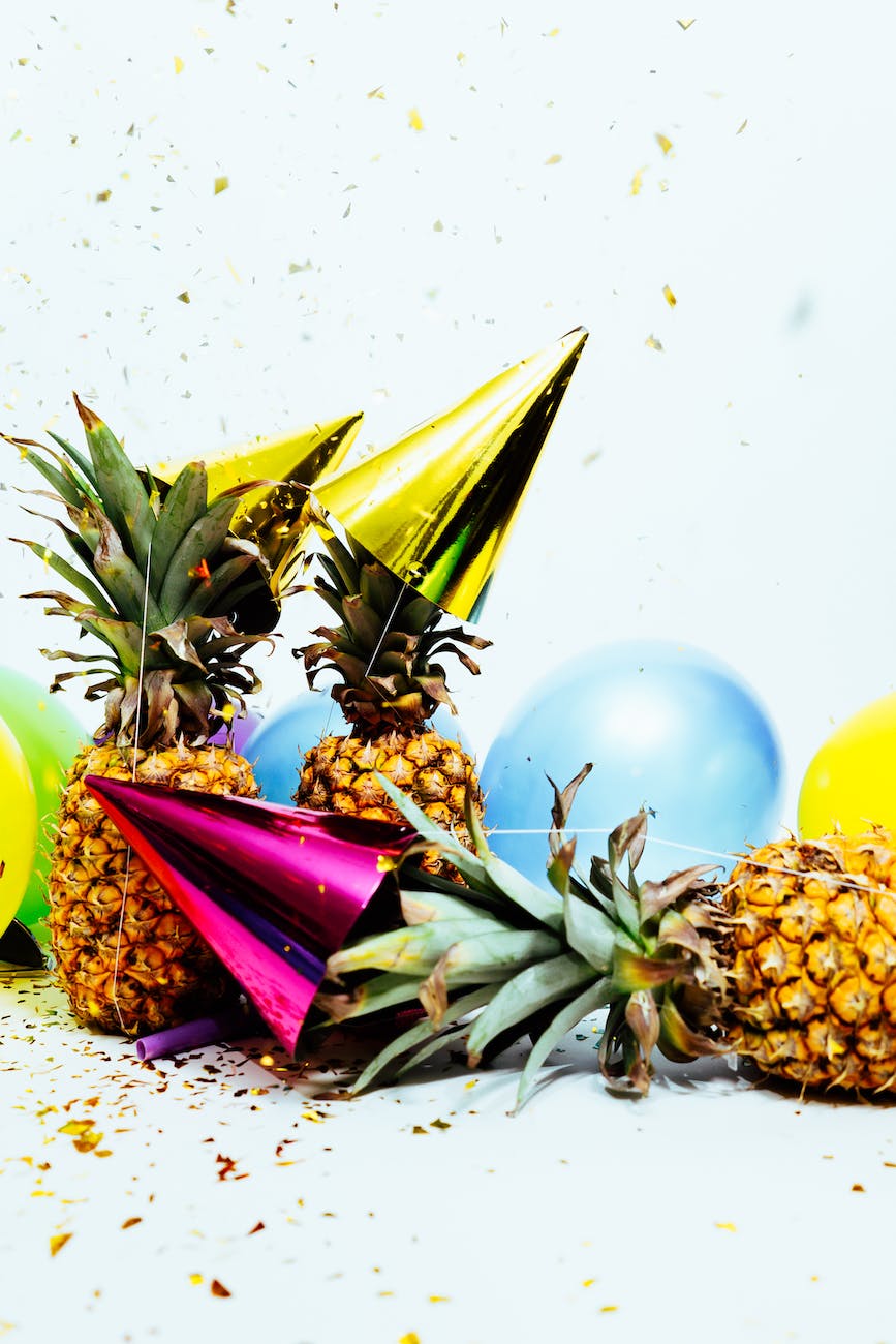 three pineapples with gold party hats